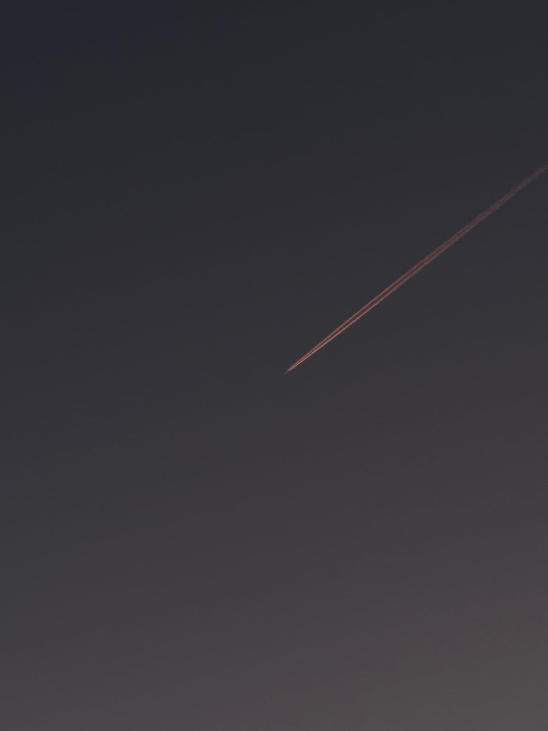 Traînée d'avion sur un ciel sombre